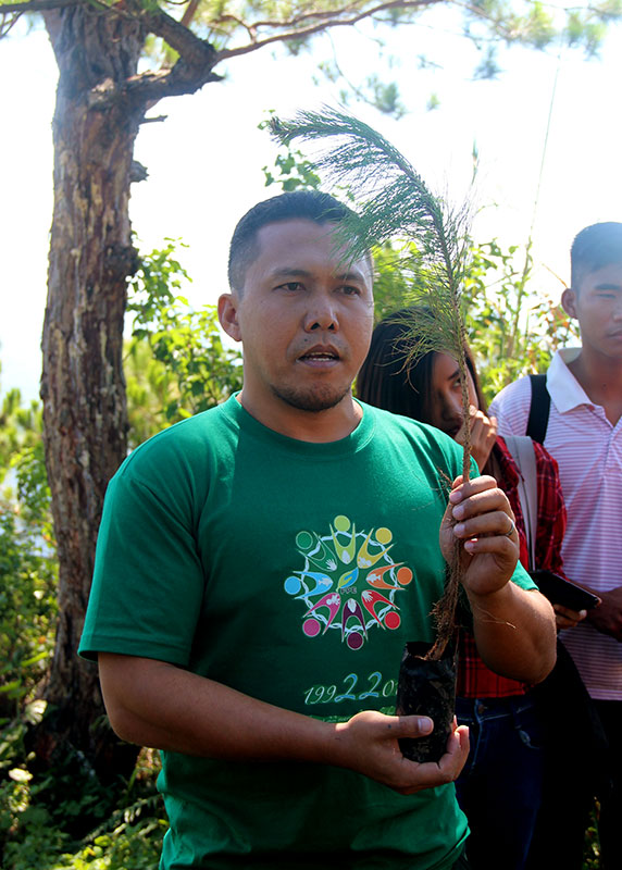 Mr. Aivan Herzano, FPE Project Officer, demonstrates the planting of pine trees.